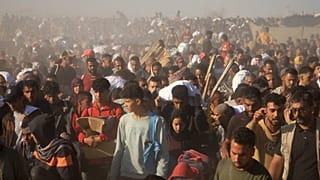 Palestinesi trasportano a Rafah, nel sud della Striscia di Gaza, scatole e borse contenenti cibo e aiuti umanitari forniti dalla Gaza Humanitarian Foundation, un'organizzazione sostenuta dagli Stati Uniti e approvata da Israele.