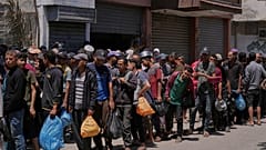 فلسطينيون يصطفون لتوزيع المواد الغذائية في دير البلح ، قطاع غزة ، الجمعة ، 30 أيار / مايو 2025.