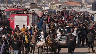 Palästinenser tragen Kisten und Taschen mit Lebensmitteln und humanitären Hilfspaketen