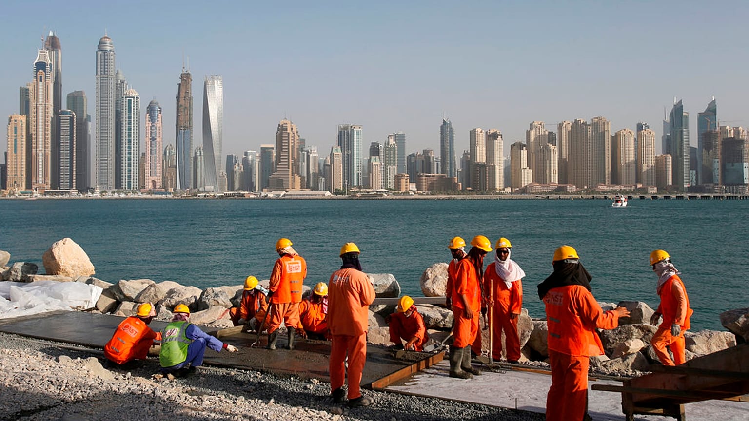 عمال يعملون في موقع بناء في نخلة جميرا ، في دبي ، الإمارات العربية الم��حدة