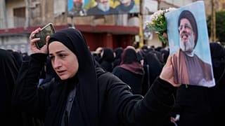 امرأة تحمل صورة زعيم حزب الله الراحل السيد حسن نصر الله، خلال موكب جنازة المسؤول في حزب الله حسن بدير وابنه علي، اللذين قُتلا، وفقًا لمسؤول في حزب الله، في غارة إسرائيلية ضربت