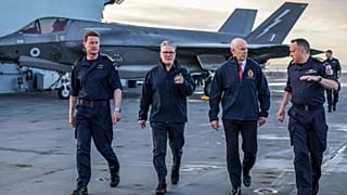 O Primeiro-Ministro britânico Keir Starmer, ao centro, à esquerda, e o Secretário de Estado da Defesa John Healy, ao centro, à direita, no HMS Prince of Wales, em Plymouth, Inglaterra, 24 de abril de 2025.