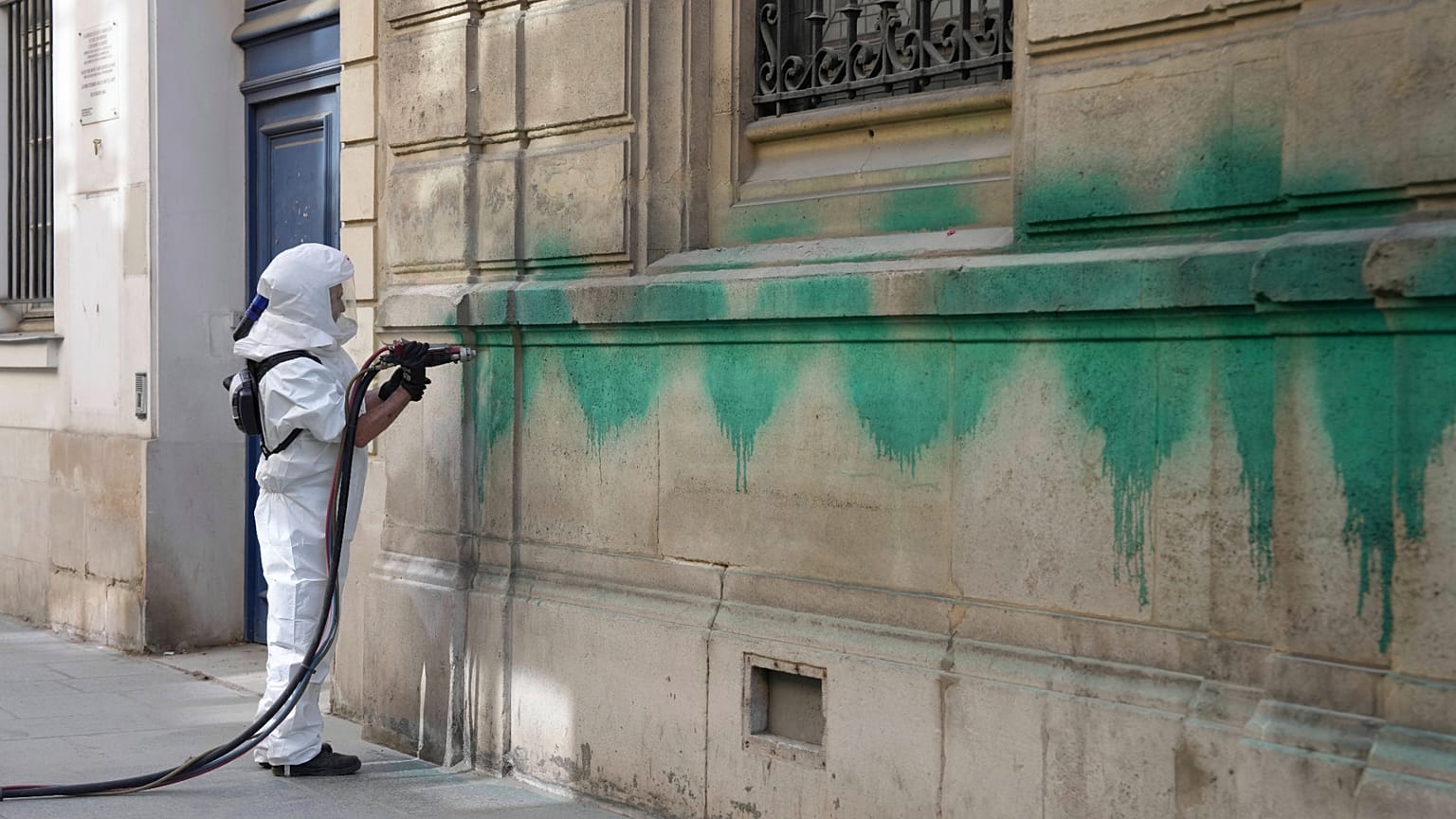 A worker cleans the defaced with green paint Synagogue des Tournelles after several Jewish sites across the capital were defaced with green paint, 31 May 2025