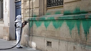 A worker cleans the defaced with green paint Synagogue des Tournelles after several Jewish sites across the capital were defaced with green paint, 31 May 2025