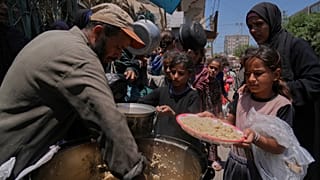 Niños palestinos reciben comida en una cocina de distribución de alimentos en Deir al-Balah, Franja de Gaza, el viernes 30 de mayo de 2025