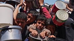 Palästinenser drängeln sich um gespendete Lebensmittel in einer Gemeinschaftsküche in Khan Younis, südlicher Gazastreifen, am Montag, 2. Juni 2025.