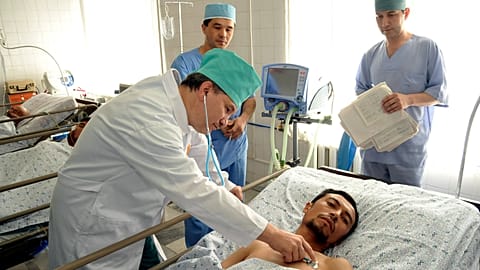 A doctor inspects a wounded Uzbek refugee Nabijon Kuchkarov who fled from the southern Kyrgyz city of Osh, 16 June, 2010