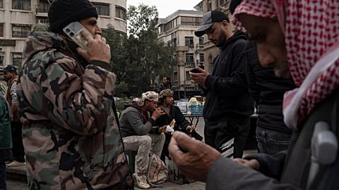 أشخاص يدخنون ويشربون الشاي في ساحة المرجة في دمشق