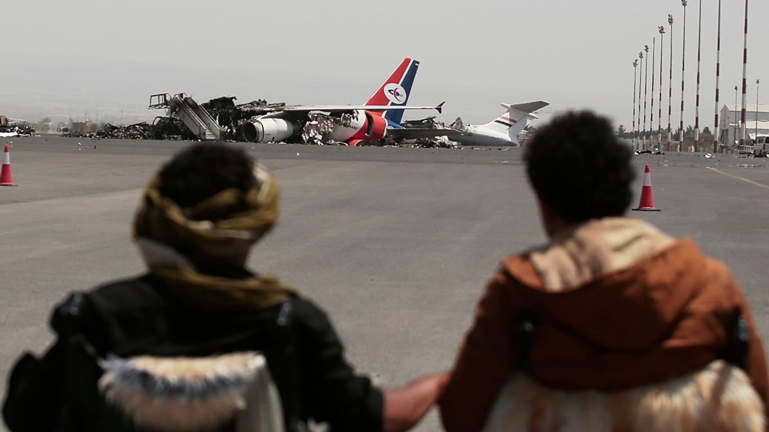 يمنيون يشاهدون طائرة يمنية معطلة في مطار صنعاء الدولي بعد يوم من الغارات الجوية الإسرائيلية على صنعاء، اليمن، الخميس 29 مايو/أيار 2025.