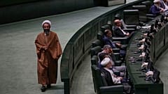نائب إيراني من رجال الدين يسير في البرلمان خلال مراسم تأبين، في طهران، إيران، الأربعاء 21 مايو/أيار 2025، للرئيس الراحل إبراهيم رئيسي وعدد من المسؤولين الذين لقوا حتفهم في حاد