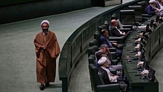 نائب إيراني من رجال الدين يسير في البرلمان خلال مراسم تأبين، في طهران، إيران، الأربعاء 21 مايو/أيار 2025، للرئيس الراحل إبراهيم رئيسي وعدد من المسؤولين الذين لقوا حتفهم في حاد