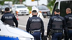 Agentes da polícia fazem recuar um homem e acompanham-no até à fronteira francesa em Kehl, Alemanha, quinta-feira, 8 de maio de 2025