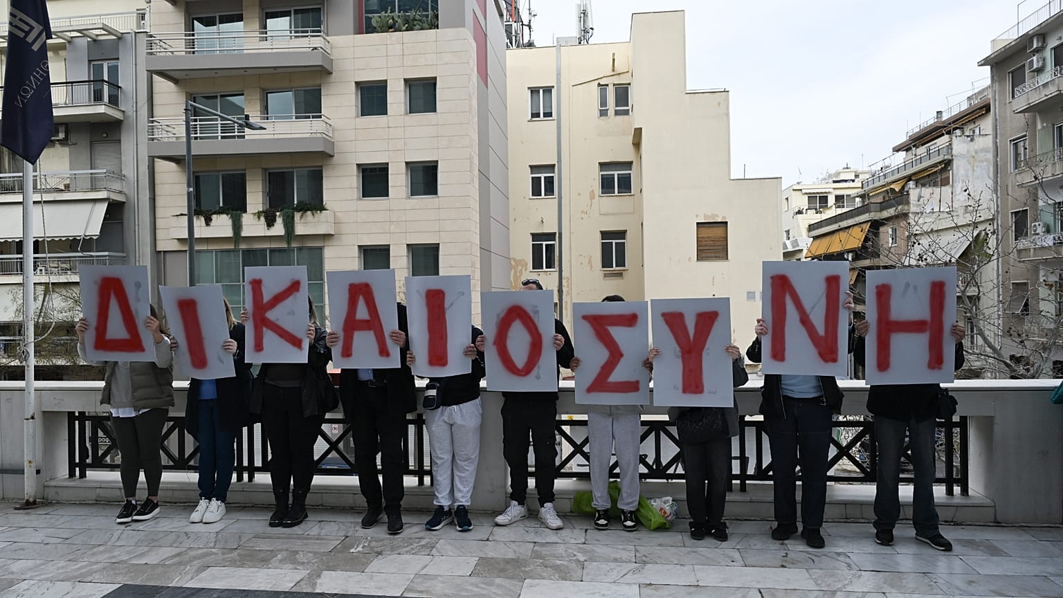 Συγγενείς των θυμάτων της πυρκαγιάς στο Μάτι κρατούν πλακάτ που σχηματίζουν τη λέξη "Δικαιοσύνη" κατά τη διάρκεια διαμαρτυρίας έξω από το Εφετείο Αθηνών