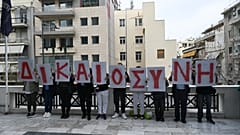 Συγγενείς των θυμάτων της πυρκαγιάς στο Μάτι κρατούν πλακάτ που σχηματίζουν τη λέξη "Δικαιοσύνη" κατά τη διάρκεια διαμαρτυρίας έξω από το Εφετείο Αθηνών