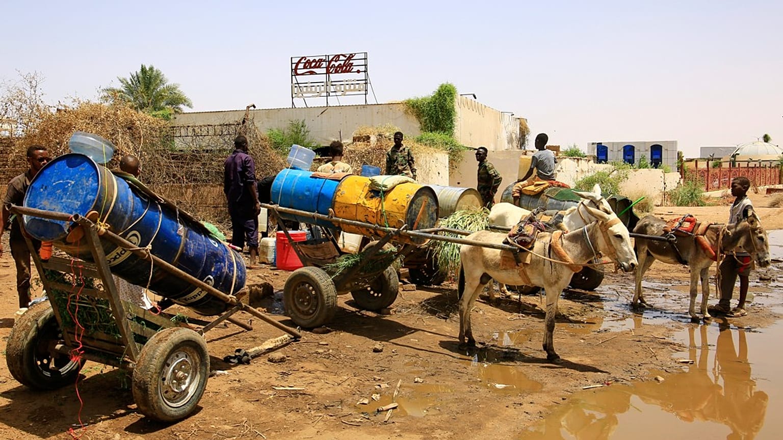 أشخاص يملأون حاويات المياه في نقطة توزيع بسبب انقطاع المياه في الخرطوم، السودان، الأحد 25 مايو 2025.  
