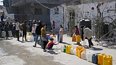 فلسطينيون يصطفون لملء عبوات بالمياه في جباليا، شمال قطاع غزة، يوم الأحد، 16 مارس 2025. 