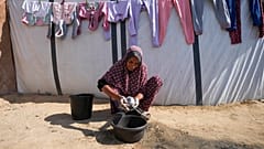 DOSYA: 51 yaşındaki Fathia Abu Mansour, 7 Kasım 2024 tarihinde Gazze Şeridi'nin Deir al-Balah kentinde yerinden edilmiş Filistinlilerin kaldığı bir kamptaki çadırının dışında mutfak eşyalarını yıkıyor.