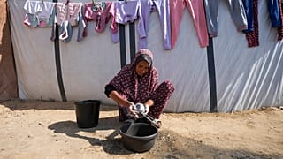 ARQUIVO: Fathia Abu Mansour, 51 anos, lava utensílios de cozinha no exterior da sua tenda num campo de deslocados palestinianos em Deir al-Balah, Faixa de Gaza, a 7 de novembro de 2024.