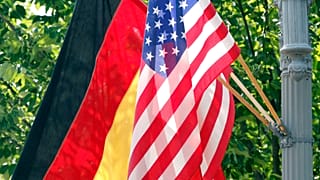 Eine deutsche und eine amerikanische Flagge vor dem Weißen Haus in Washington