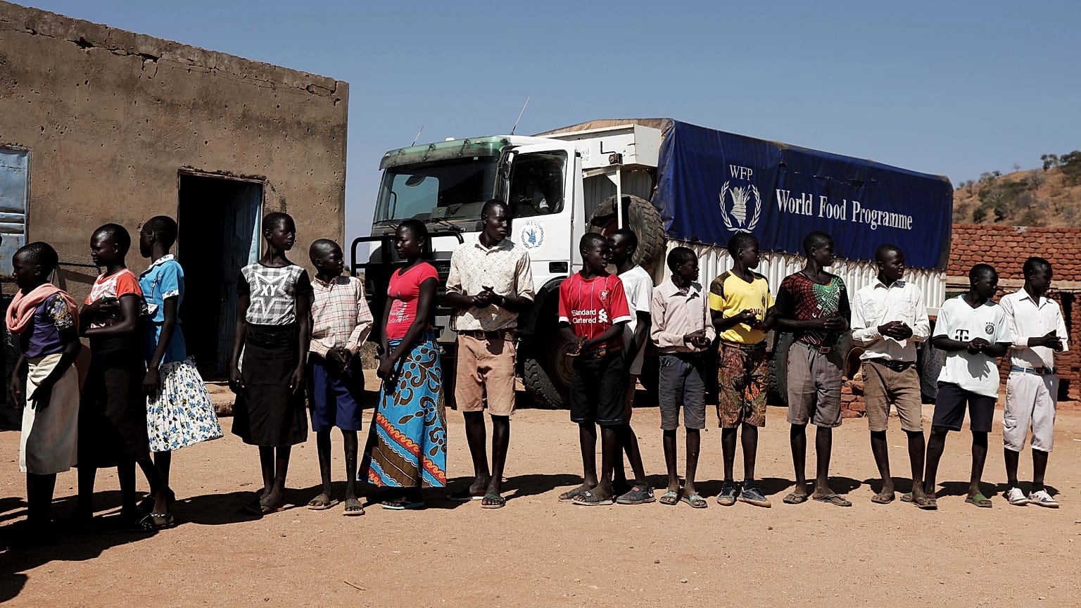 Children wait in line to receive aid during a visit organised by The World Food Program in the town of Kauda, 9 January, 2020