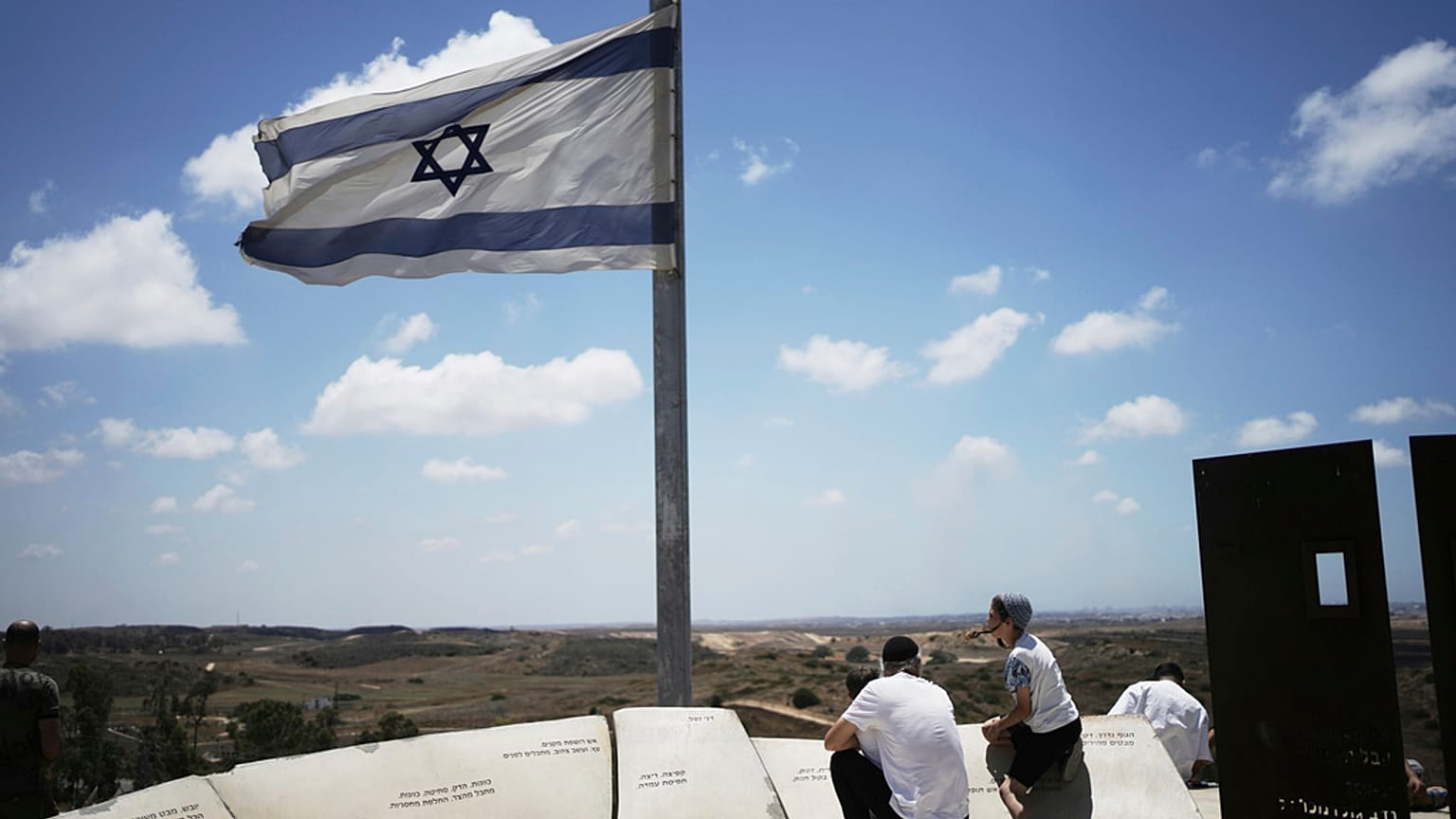 Ein Mann und seine Söhne beobachten von einem Aussichtspunkt in Sderot, Südisrael, am jüdischen Feiertag Schawuot, den Rauch der israelischen Bombardierung