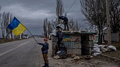 ARQUIVO - Crianças ucranianas brincam num posto de controlo abandonado em Kherson, no sul da Ucrânia, quarta-feira, 23 de novembro de 2022. 
