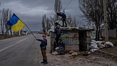 Ukrainische Kinder spielen an einem verlassenen Kontrollpunkt in Kherson, Südukraine, Mittwoch, 23. November 2022.