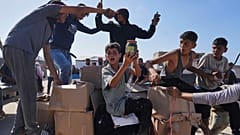 فلسطينيون يحملون مساعدات إنسانية قدمتها مؤسسة غزة الإنسانية، في رفح، جنوب قطاع غزة، يوم الثلاثاء، 27 مايو 2025. 