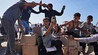 فلسطينيون يحملون مساعدات إنسانية قدمتها مؤسسة غزة الإنسانية، في رفح، جنوب قطاع غزة، يوم الثلاثاء، 27 مايو 2025.