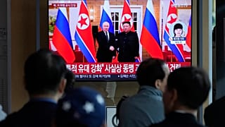 Um ecrã de televisão mostra uma imagem de arquivo do líder norte-coreano Kim Jong Un, à direita, e do Presidente russo Vladimir Putin em Pyongyang.