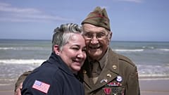 Der Veteran des Zweiten Weltkriegs Wilbur Myers posiert am 2. Juni 2025 bei einem Besuch am Omaha Beach für ein Foto mit einer Frau. Omaha Beach war am 6. Juni 1944 einer der Landungsorte des D-Days.