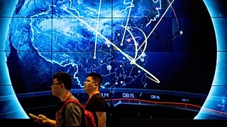 Os participantes passam por um ecrã eletrónico que mostra os ciberataques recentes na China durante a Conferência sobre Segurança da Internet na China, em Pequim, a 12 de setembro de 2017