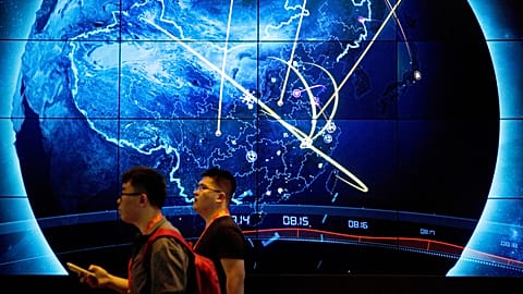 Attendees walk past an electronic display showing recent cyberattacks in China at the China Internet Security Conference in Beijing, 12 September, 2017