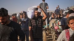 فلسطينيون يحملون صناديق وأكياس تحتوي على مواد غذائية ومساعدات إنسانية قدمتها مؤسسة غزة الإنسانية، رفح، جنوب قطاع غزة، 29 مايو 2025
