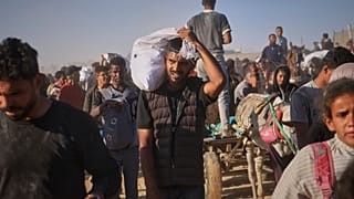 فلسطينيون يحملون صناديق وأكياس تحتوي على مواد غذائية ومساعدات إنسانية قدمتها مؤسسة غزة الإنسانية، رفح، جنوب قطاع غزة، 29 مايو 2025