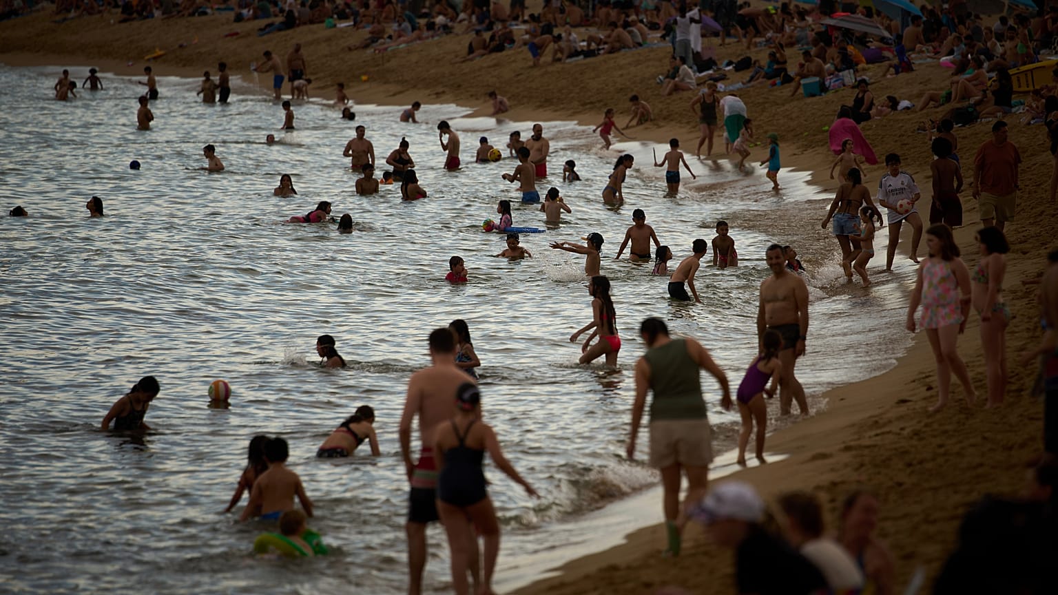 Bañistas se refrescan durante las altas temperaturas en una playa de Barcelona, ​​España, el sábado 31 de mayo de 2025.