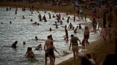 Bañistas se refrescan durante las altas temperaturas en una playa de Barcelona, ​​España, el sábado 31 de mayo de 2025.