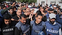 Trauernde tragen den Leichnam des palästinensischen Journalisten Hassan Eslaiah, der bei einem nächtlichen israelischen Angriff auf das Nasser-Krankenhaus in Khan Younis, Gaza, getötet wurde, Dienstag, 13. Mai 2025