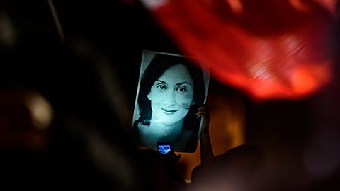 A protester holds up a picture of Daphne Caruana Galizia during a demonstration outside Malta's prime minister's office in Valletta, 27 November, 2019