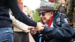 El veterano de la Segunda Guerra Mundial Jake Larson se reúne con jóvenes en la conmemoración del 81º aniversario del desembarco del Día D, este viernes en Colleville-sur-Mer.