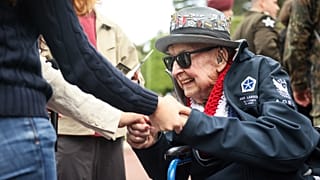 El veterano de la Segunda Guerra Mundial Jake Larson se reúne con jóvenes en la conmemoración del 81º aniversario del desembarco del Día D, este viernes en Colleville-sur-Mer.