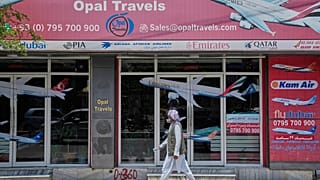 An Afghan person passes in front of an air travel agency in Kabul, Afghanistan.