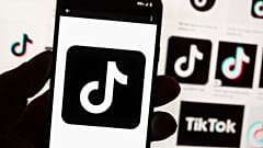 Το λογότυπο του TikTok σε ένα κινητό τηλέφωνο μπροστά από μια οθόνη υπολογιστή που εμφανίζει την αρχική οθόνη του TikTok στη Βοστώνη, 14 Οκτωβρίου 2022.