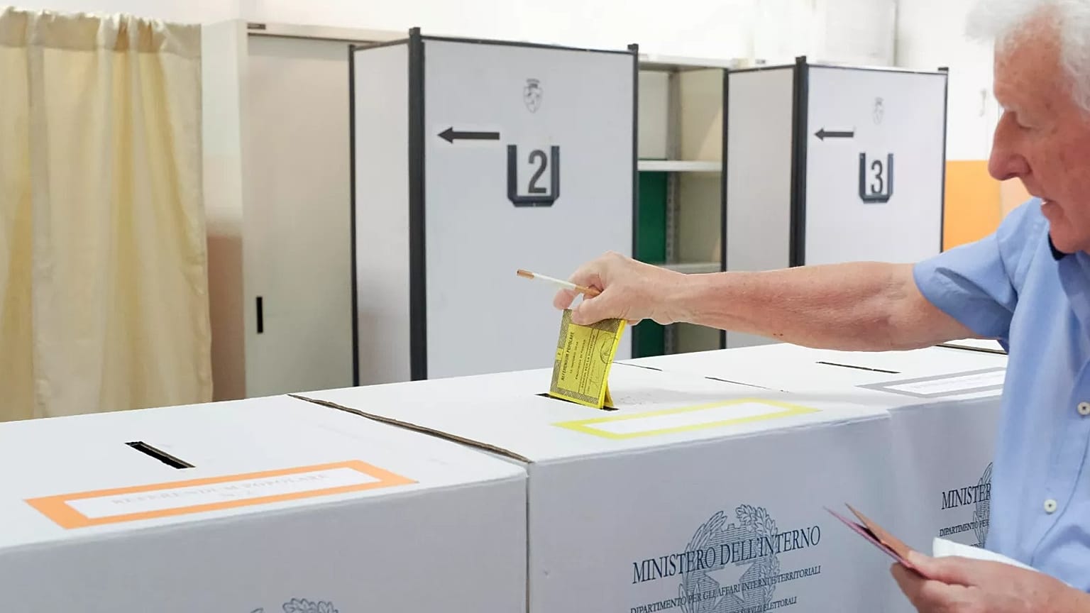 Un elettore deposita la scheda in un seggio a Torino, per un referendum sulla giustizia il 12 giugno 2022