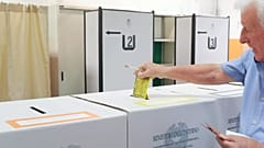 Un elettore deposita la scheda in un seggio a Torino, per un referendum sulla giustizia il 12 giugno 2022