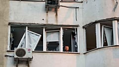 Bir adam, 6 Haziran 2025 Cuma günü Ukrayna'nın başkenti Kiev'de Rus insansız hava aracının saldırısı sonrasında hasar gören çok katlı bir konut binasının penceresinden bakıyor. (AP Fotoğrafı/Evgeniy Maloletka)
