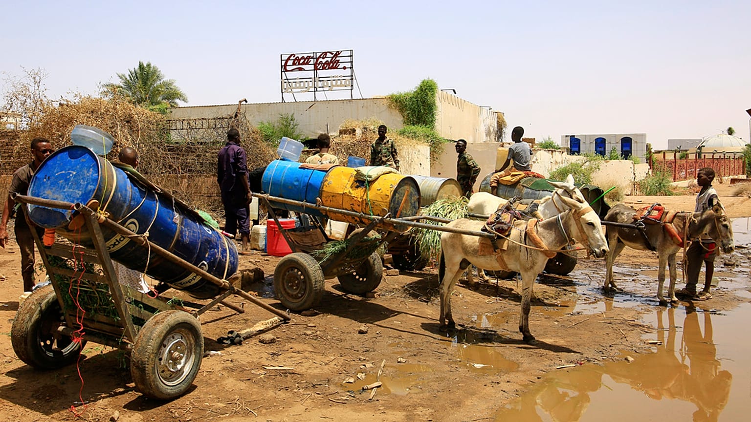 أشخاص يملأون حاويات المياه في نقطة توزيع بسبب انقطاع المياه في الخرطوم ، السودان ، الأحد 25 مايو 2025