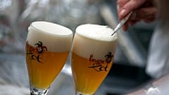 DATEI - Auf diesem Dateifoto vom Donnerstag, 26. Mai 2016, kratzt ein Arbeiter in Brügge, Belgien, den Schaum von einem Glas Bier ab, bevor er es serviert. 