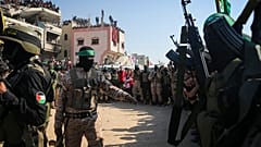 مسلحون من حماس والجهاد الإسلامي يؤمنون المنطقة بينما ينتظر ممثلو الصليب الأحمر تسليم الرهائن التايلانديين والإسرائيليين في خان يونس.  