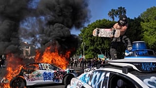 Автомобиль Waymo подвергается вандализму, в то время как другой горит рядом с Центром содержания под стражей Метрополитен в центре Лос-Анджелеса, воскресенье, 8 июня 2025 года, после вчерашней акции протеста против иммиграционного рейда.